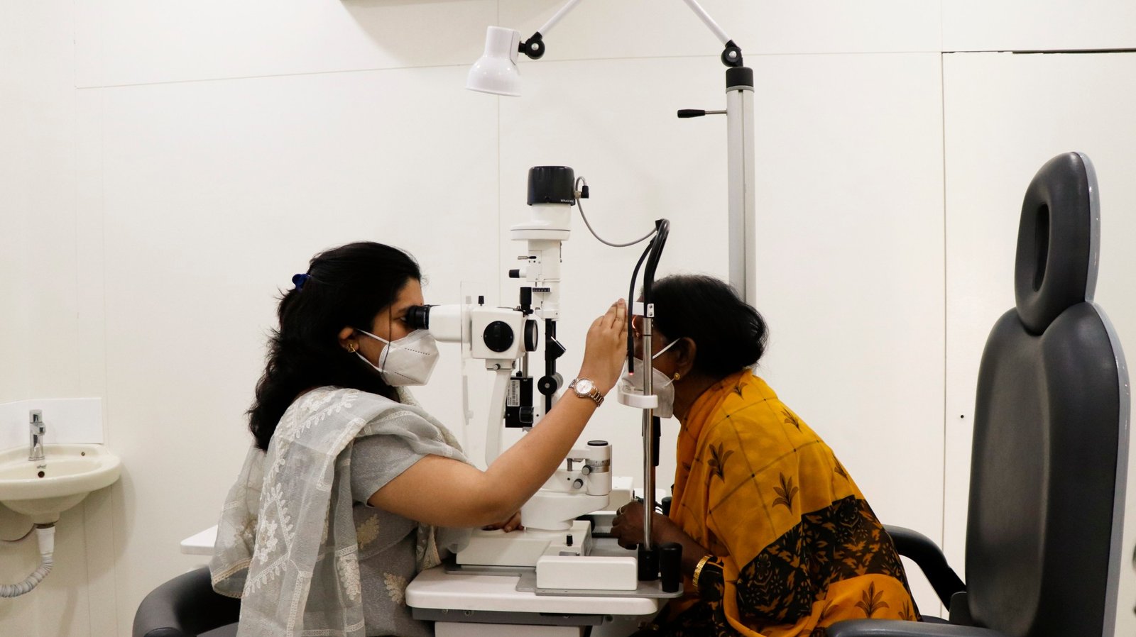 An ophthalmologist at Aastha Eye Care examining a patient at the slit lamp.