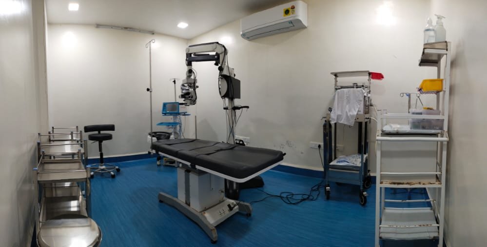 The operating theatre at Aastha Eye Care, set up with an operating microscope and surgical table.